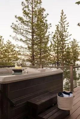 a bath tub sitting on top of a wooden deck at Alpenglow Aerie - StayLuxe Rubicon in Meeks Bay