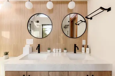 a bathroom with two sinks and two mirrors at Alpenglow Aerie - StayLuxe Rubicon in Meeks Bay