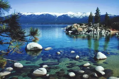 a large body of water with rocks and mountains at The Gathering Place in Truckee