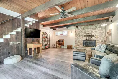 a living room with a couch and a stone fireplace at Mtn-View Gem Deck, Grill and Fire Pit in West Point in Volcano