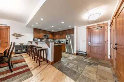 a kitchen with wooden cabinets and a table and chairs at Big Horn Lodge 307 by East West Hospitality in Truckee