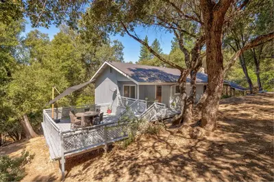 a white house with a tree in front of it at Bald Bear Barracks in Mariposa