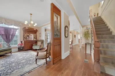 a living room with a staircase and a stair case at Timeless Victorian Gem w Breathtaking Mountains in Sutter Creek