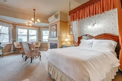 a bedroom with a large bed and a table and chairs at Romantic Victorian Getaway The Garden in Sutter Creek