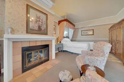 a living room with a fireplace and a bedroom at Romantic Victorian Getaway The Garden in Sutter Creek