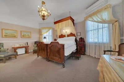 a large bedroom with a bed and a chandelier at Romantic Victorian Getaway The Blue Room in Sutter Creek
