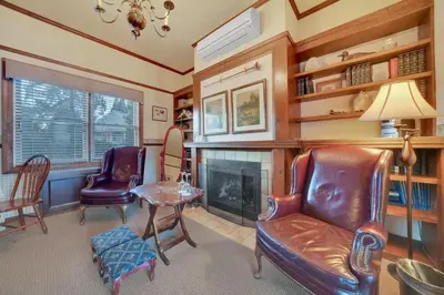 a living room with two chairs and a fireplace at Romantic Victorian Getaway The Fox in Sutter Creek