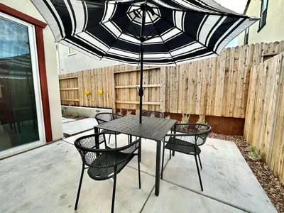 a table and chairs with an umbrella on a patio at Charming and Modern 3-Bedroom Home in Rocklin in Rocklin