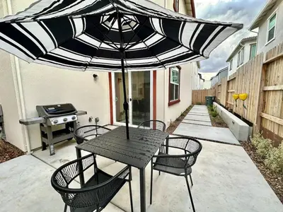 a table and chairs with an umbrella on a patio at Charming and Modern 3-Bedroom Home in Rocklin in Rocklin