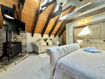 a bedroom with a bed and a tv and a fireplace at Cozy Tahoe Retreat Huge Yard in South Lake Tahoe