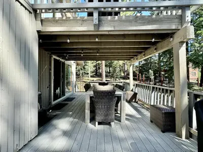 a wooden deck with a table and chairs on it at Cozy Tahoe Retreat Huge Yard in South Lake Tahoe