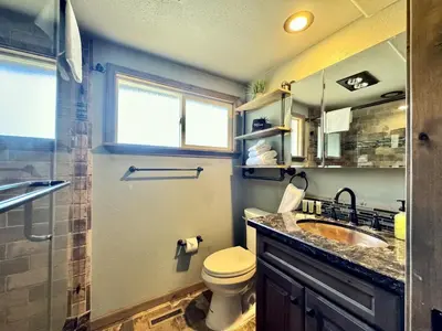 a bathroom with a toilet and a sink and a window at Cozy Tahoe Retreat Huge Yard in South Lake Tahoe