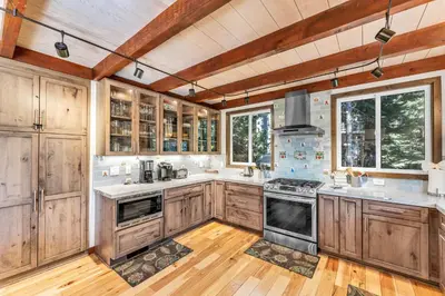 a kitchen with wooden cabinets and a stove top oven at Updated Tahoe Retreat Near Trails with Game Room in Kings Beach