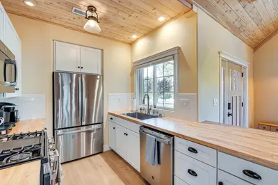 a kitchen with white cabinets and a wooden ceiling at Auburn Farmhouse with Fireplace, Close to Wineries in Auburn