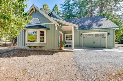 a green house with a garage and a driveway at Auburn Farmhouse with Fireplace, Close to Wineries in Auburn