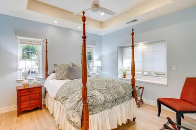 a bedroom with a four poster bed and a red chair at Auburn Farmhouse with Fireplace, Close to Wineries in Auburn