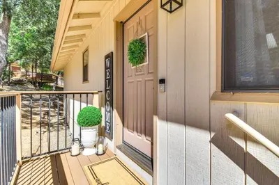 a porch of a house with a door and a plant at 1 Mi to Pine Mountain Lake Marina Yosemite Cabin! in Groveland