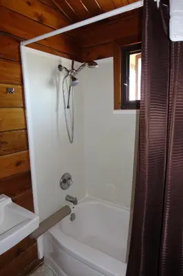 a bathroom with a white tub and a toilet at Big Meadow Lodge in Bridgeport