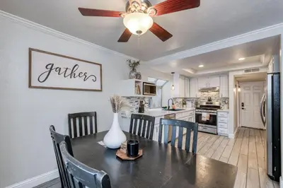 a kitchen with a dining table and a ceiling fan at Chic Boho 3BR Home Near Woodward Park in Fresno