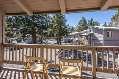 two chairs on a porch with a view of a house at Mammoth TwnHm hot tub walk to town in Mammoth Lakes