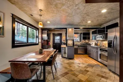 a large kitchen with a wooden table and stainless steel appliances at New Cabin in North Lake Tahoe! in Kings Beach