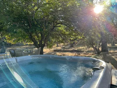 a hot tub in the middle of a field with trees at Picturesque Yosemite A-Frame in Mariposa
