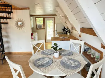 a dining room with a white table and chairs at Picturesque Yosemite A-Frame in Mariposa