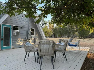 a patio with a table and chairs on a deck at Picturesque Yosemite A-Frame in Mariposa