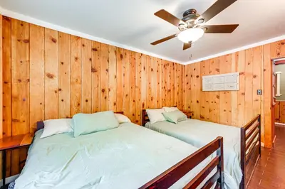 two beds in a room with wooden walls at Idyllic Home in Kernville with Private Beach Access in Kernville