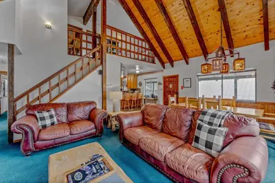 a living room with two leather couches and a staircase at Near Northstar Wooded Retreat with Deck & Loft in Tahoe Vista