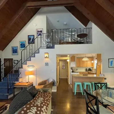 a living room and kitchen with a staircase in a house at Spacious family home on the Meadow Monthly Only in South Lake Tahoe