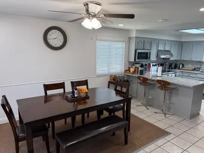 a kitchen with a dining table and a clock on the wall at Charming 3 Bedroom Farmhouse Retreat with Open Deck in Acampo