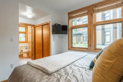a bedroom with a bed and two windows at Solstice 17 in Mammoth Lakes