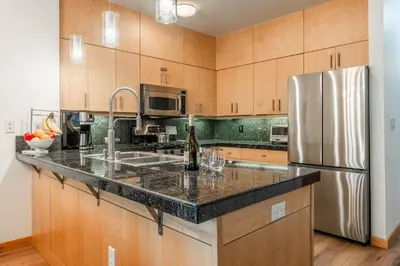 a kitchen with wooden cabinets and a stainless steel refrigerator at Solstice 17 in Mammoth Lakes