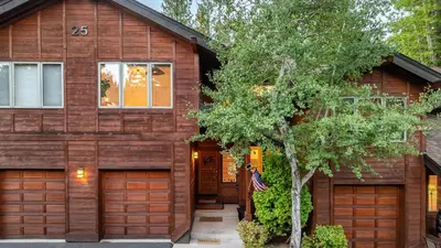 a house with two garage doors and a tree at Northwood Mountain Views Sauna Balcony Tahoe Group Retreat in Incline Village