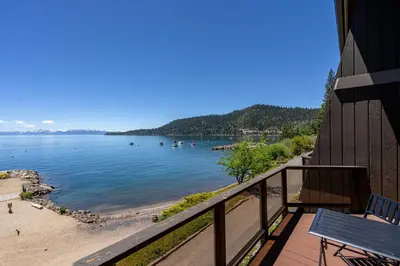 a balcony with a view of a beach and the water at Newley remodeled, two story, two-bedroom condo nothing but Views of Lake Tahoe! in Incline Village