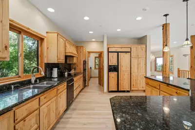 a large kitchen with wooden cabinets and black counter tops at Do not miss your chance to vacation at this five bedroom 5 bath mountain home in Incline Village