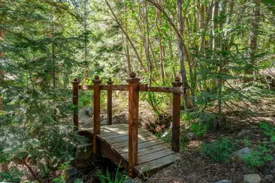 a wooden bridge in the middle of a forest at Do not miss your chance to vacation at this five bedroom 5 bath mountain home in Incline Village