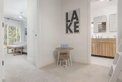 a white living room with a table and a bed at Luxury Lake Home-The Bear Claw-Boat Slip-Sleeps 16 in Bass Lake