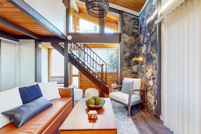 a living room with a couch and a stone wall at Mountain Serenity, near Ski, Golf, Casino, Lake in Stateline