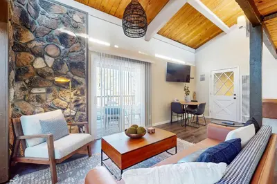 a living room with a stone wall at Mountain Serenity, near Ski, Golf, Casino, Lake in Stateline