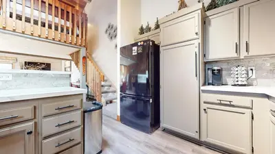a kitchen with a black refrigerator and white cabinets at Snowcreek II #220 condo in Mammoth Lakes