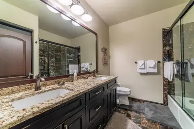 a bathroom with two sinks and a toilet and a mirror at Grand Townhome w/ Meadow Views; Private Garage in Mammoth Lakes