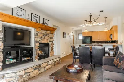 a living room with a fireplace and a tv at Mammoth Green #210 - Nearly Ski-in Ski-Out 2 Bedroom 2 Bath, Sleeps 6 on Golf Course in Mammoth Lakes