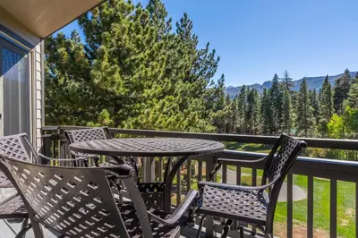 a patio with a table and chairs on a balcony at Mammoth Green #210 - Nearly Ski-in Ski-Out 2 Bedroom 2 Bath, Sleeps 6 on Golf Course in Mammoth Lakes