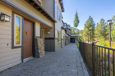a walkway next to a house with a fence at Mammoth Green #210 - Nearly Ski-in Ski-Out 2 Bedroom 2 Bath, Sleeps 6 on Golf Course in Mammoth Lakes