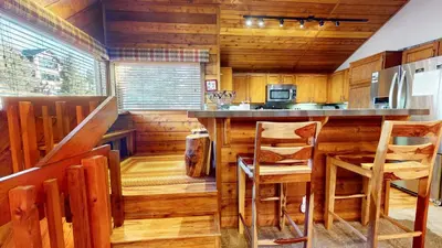 a kitchen with wooden walls and a counter with chairs at Snowcreek I #47 condo in Mammoth Lakes