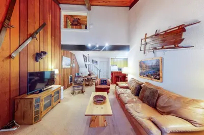 a living room with a leather couch and a tv at Chamonix 36 in Mammoth Lakes