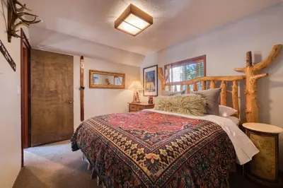 a bedroom with a bed with a wooden head board at Spire Chalet at Alpine Meadows - 4BR W Hot Tub and Ski Shuttle in Alpine Meadows