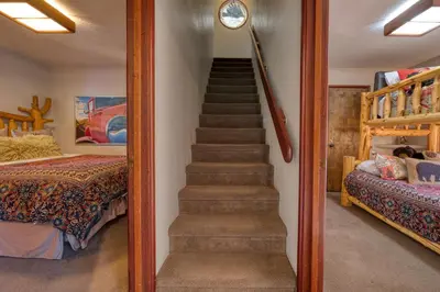 a staircase leading up to a bedroom with a bed at Spire Chalet at Alpine Meadows - 4BR W Hot Tub and Ski Shuttle in Alpine Meadows
